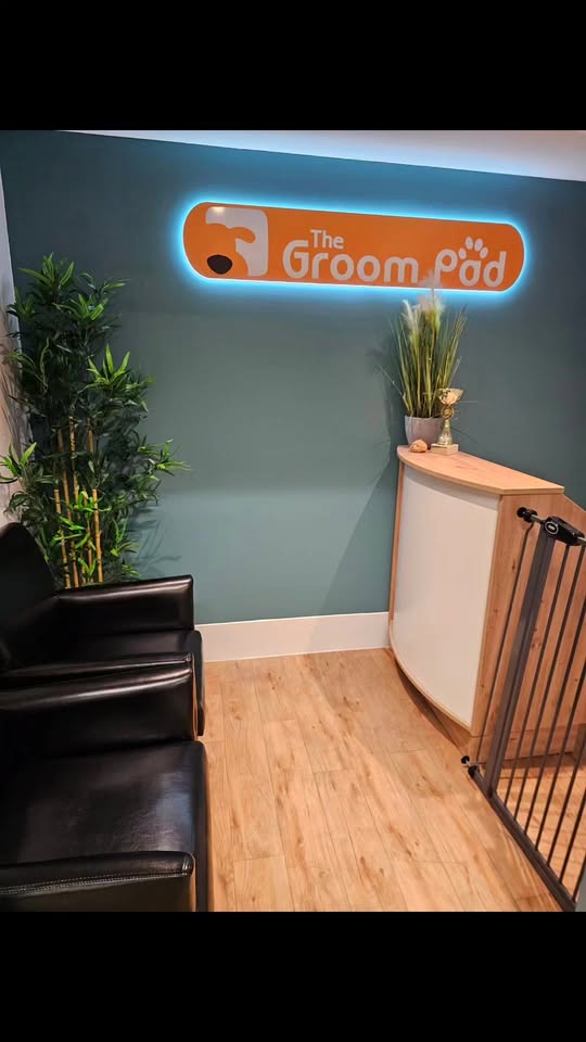 The Groom Pad reception, with the salon's illuminated logo sign on the wall